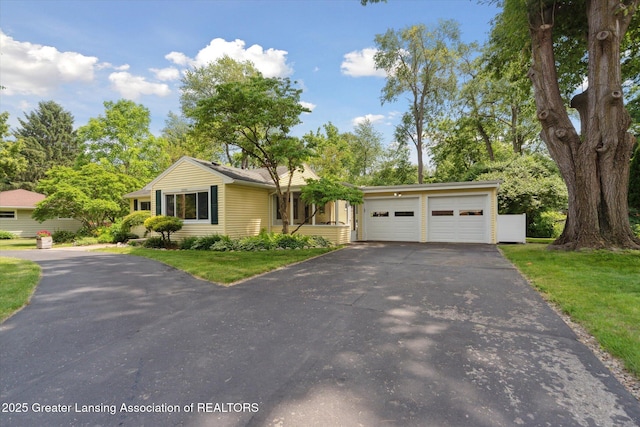 2391 Shawnee Trl, Okemos, MI 48864 - view of front of house featuring driveway, a garage, and a front lawn