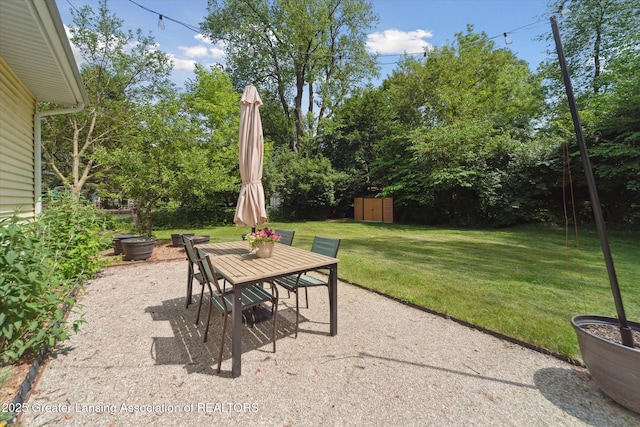 2391 Shawnee Trl, Okemos, MI 48864 - view of patio / terrace featuring a shed, outdoor dining space, and view of wooded area