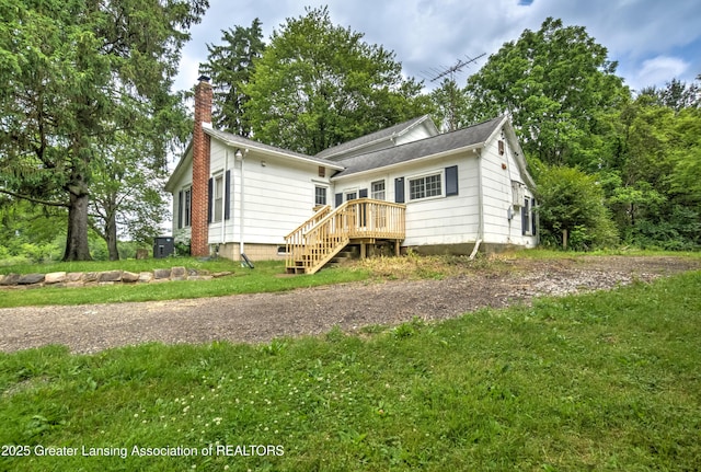 6631 Springport Rd, Jackson, MI 49201 - view of front of home with a chimney, stairs, a deck, and a front yard