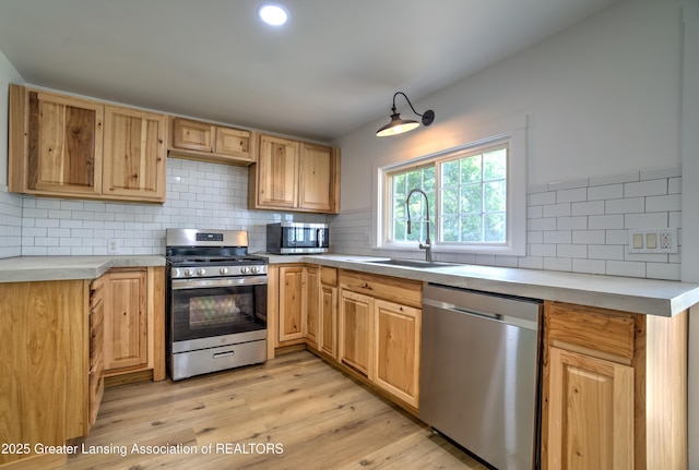 6631 Springport Rd, Jackson, MI 49201 - kitchen with stainless steel appliances, backsplash, light wood-style flooring, light brown cabinetry, and recessed lighting