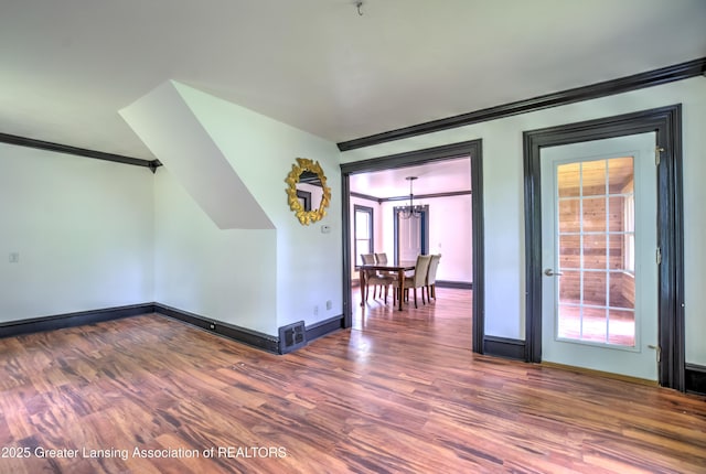 6631 Springport Rd, Jackson, MI 49201 - spare room featuring ornamental molding, wood finished floors, plenty of natural light, and a chandelier