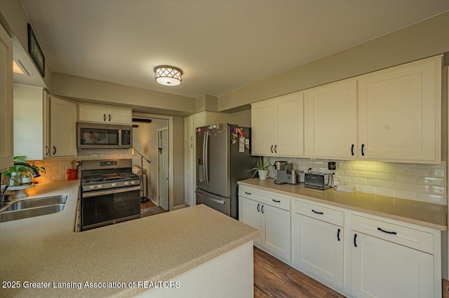2300 Hampshire Rd, Lansing, MI 48911 - kitchen featuring appliances with stainless steel finishes, decorative backsplash, light countertops, and white cabinetry