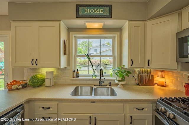 2300 Hampshire Rd, Lansing, MI 48911 - kitchen with white cabinets, appliances with stainless steel finishes, light countertops, and decorative backsplash