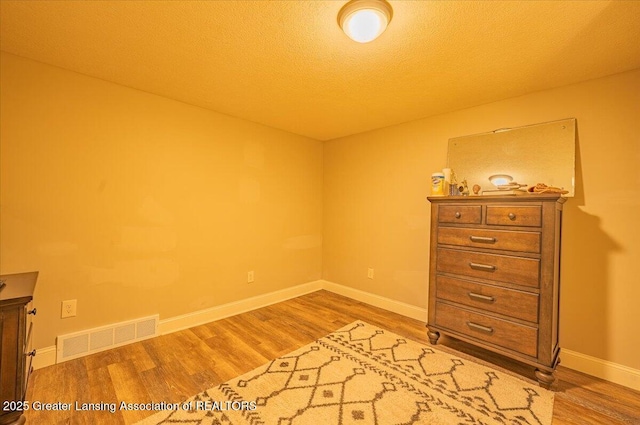 2300 Hampshire Rd, Lansing, MI 48911 - unfurnished bedroom featuring wood finished floors and a textured ceiling