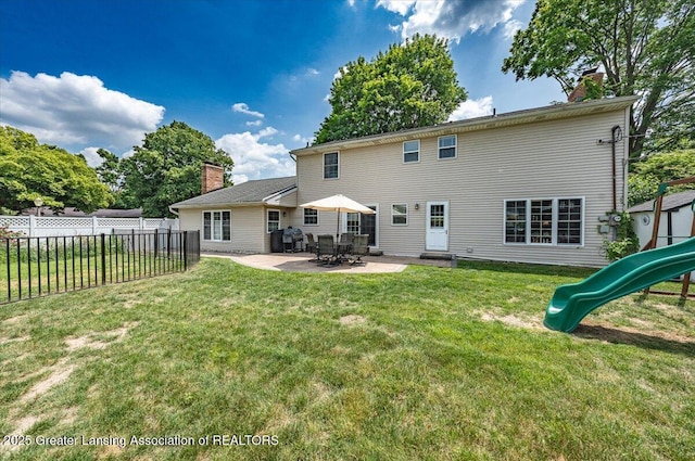 2300 Hampshire Rd, Lansing, MI 48911 - back of house with a chimney, a playground, and a patio area