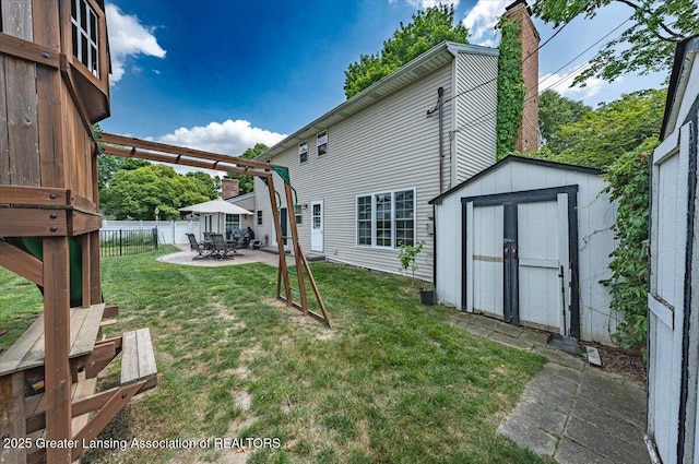 2300 Hampshire Rd, Lansing, MI 48911 - back of house featuring a chimney, a shed, and a patio area