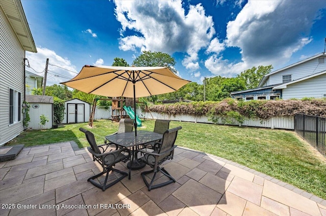 2300 Hampshire Rd, Lansing, MI 48911 - fenced backyard with a storage unit, a patio area, a playground, and outdoor dining area