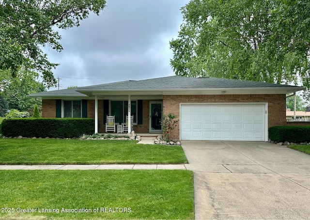 4624 Meaford St, Lansing, MI 48917 - ranch-style home featuring a front yard, concrete driveway, an attached garage, covered porch, and brick siding