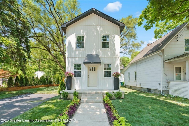 1033 May St, Lansing, MI 48906 - view of front facade with a front yard and board and batten siding