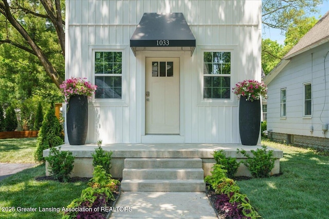 1033 May St, Lansing, MI 48906 - entrance to property with board and batten siding and a lawn