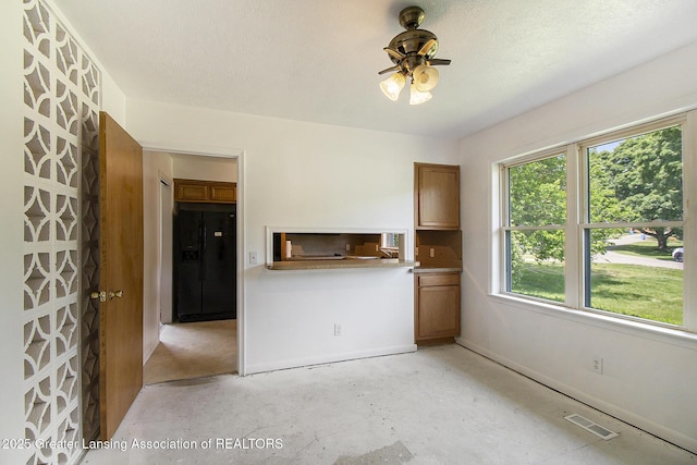3739 Ridgefield Rd, Lansing, MI 48906 - unfurnished dining area featuring a ceiling fan and unfinished concrete flooring