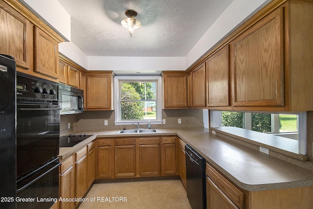 3739 Ridgefield Rd, Lansing, MI 48906 - kitchen featuring black appliances, a textured ceiling, brown cabinetry, and a peninsula