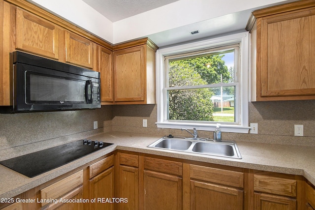 3739 Ridgefield Rd, Lansing, MI 48906 - kitchen with black appliances, tasteful backsplash, light countertops, and brown cabinets