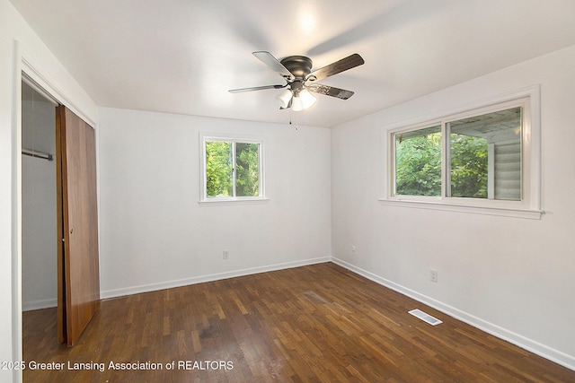 3739 Ridgefield Rd, Lansing, MI 48906 - unfurnished bedroom with dark wood-style flooring, a closet, and a ceiling fan