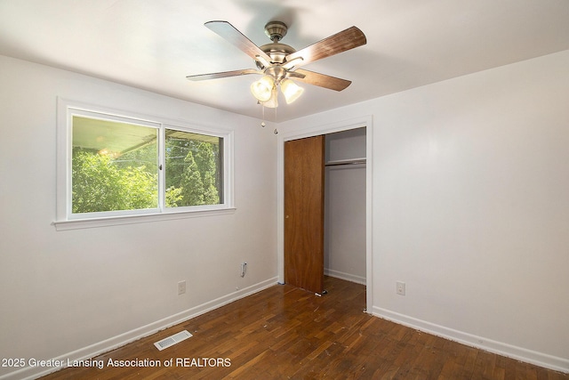 3739 Ridgefield Rd, Lansing, MI 48906 - unfurnished bedroom featuring dark wood-style floors, a closet, and a ceiling fan