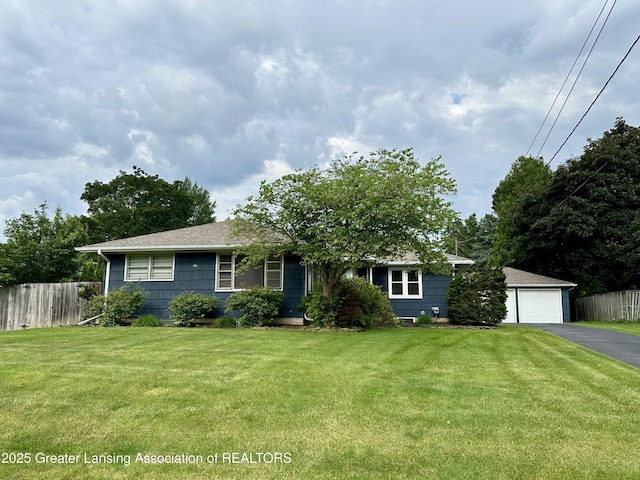 943 Lantern Hill Dr, East Lansing, MI 48823 - view of front facade with driveway, a detached garage, and a shingled roof