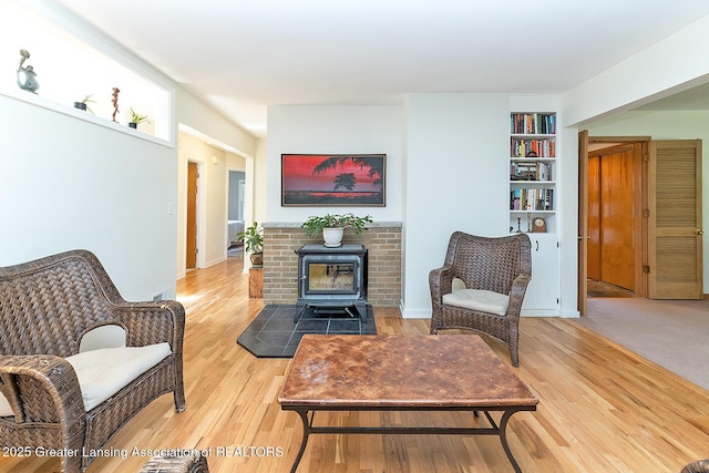 943 Lantern Hill Dr, East Lansing, MI 48823 - living area with a wood stove, wood finished floors, and built in shelves
