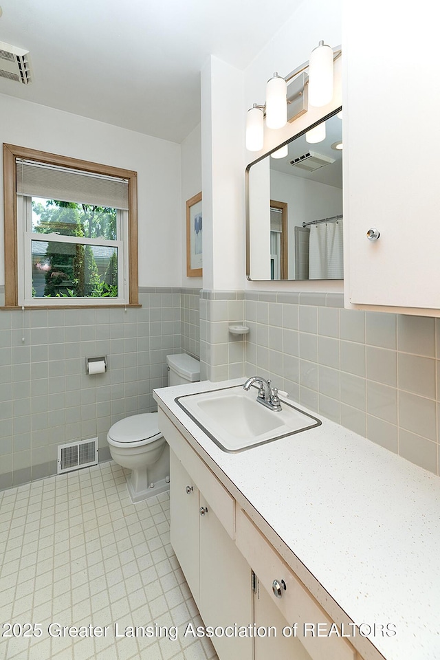 943 Lantern Hill Dr, East Lansing, MI 48823 - full bath with tile patterned flooring, vanity, tile walls, and wainscoting