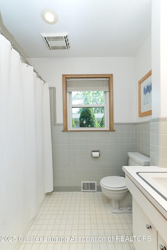 943 Lantern Hill Dr, East Lansing, MI 48823 - full bath with tile walls, tile patterned floors, vanity, a wainscoted wall, and a shower with shower curtain