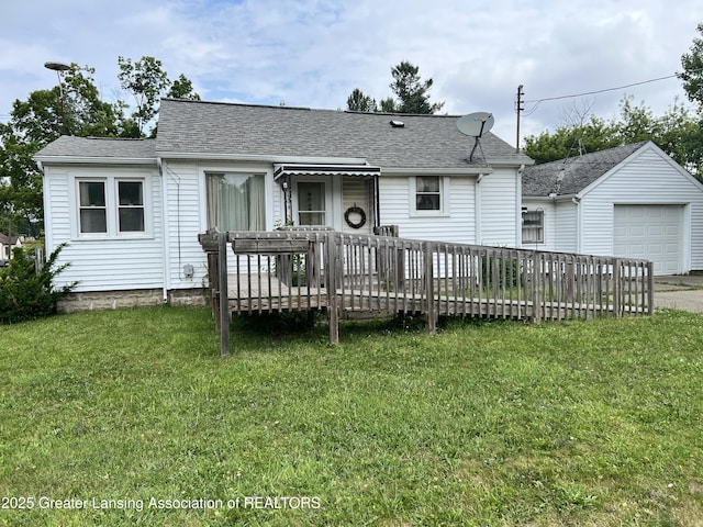 500 N Catherine St, Lansing, MI 48917 - view of front facade with a wooden deck, a front lawn, a shingled roof, a detached garage, and an outbuilding