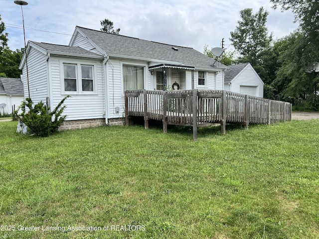 500 N Catherine St, Lansing, MI 48917 - rear view of property with a deck, a yard, a shingled roof, and a garage