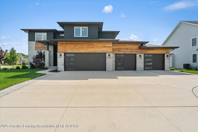 6102 Sleepy Hollow Ln, East Lansing, MI 48823 - modern home featuring driveway, a front lawn, and a garage