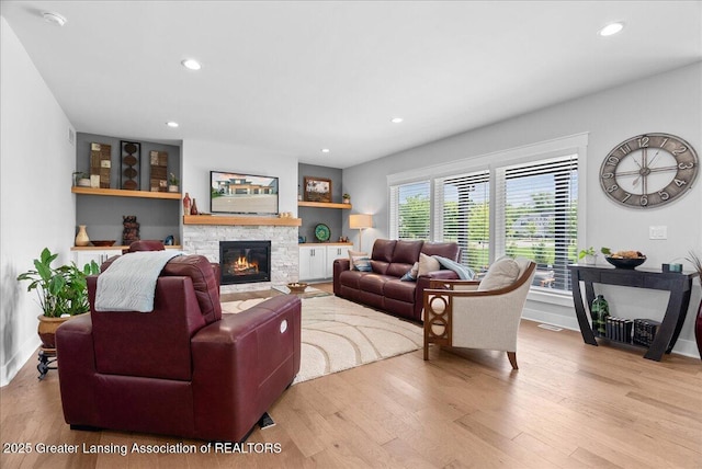 6102 Sleepy Hollow Ln, East Lansing, MI 48823 - living room with wood finished floors, a stone fireplace, and recessed lighting