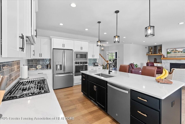 6102 Sleepy Hollow Ln, East Lansing, MI 48823 - kitchen with appliances with stainless steel finishes, white cabinetry, dark cabinetry, recessed lighting, and tasteful backsplash