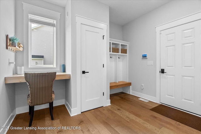 6102 Sleepy Hollow Ln, East Lansing, MI 48823 - mudroom with built in desk and wood finished floors