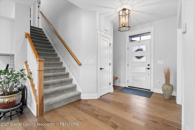 6102 Sleepy Hollow Ln, East Lansing, MI 48823 - foyer featuring wood finished floors, stairs, and a chandelier