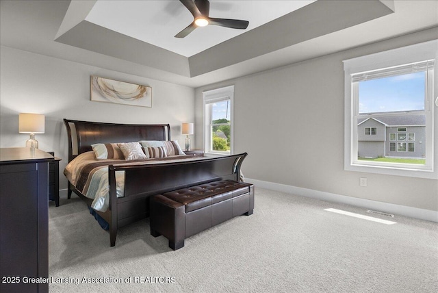 6102 Sleepy Hollow Ln, East Lansing, MI 48823 - carpeted bedroom with a tray ceiling and a ceiling fan