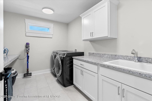 6102 Sleepy Hollow Ln, East Lansing, MI 48823 - laundry area with cabinet space, washer and clothes dryer, and light tile patterned flooring