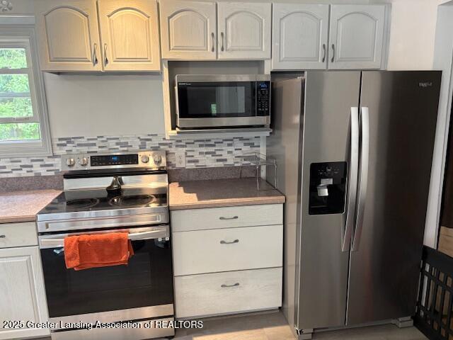6321 Marywood Ave, Lansing, MI 48911 - kitchen with stainless steel appliances and decorative backsplash