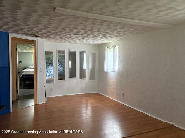 6321 Marywood Ave, Lansing, MI 48911 - empty room with wood finished floors and a textured wall