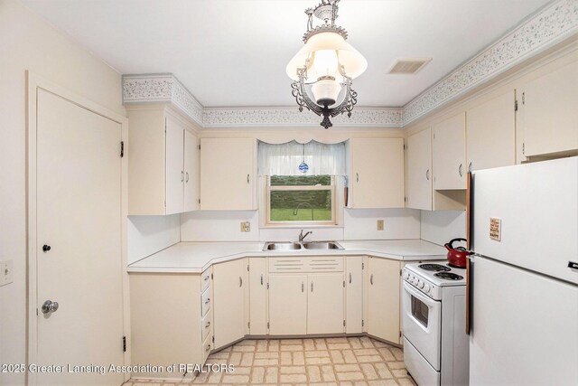 2782 Roseland Ave, East Lansing, MI 48823 - kitchen with white appliances, light countertops, brick patterned floors, and cream cabinetry