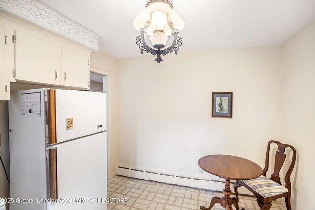 2782 Roseland Ave, East Lansing, MI 48823 - kitchen with freestanding refrigerator, brick patterned floors, white cabinetry, and a baseboard radiator