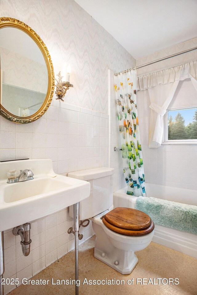 2782 Roseland Ave, East Lansing, MI 48823 - full bathroom with tile walls, wallpapered walls, and shower / bath combination with curtain