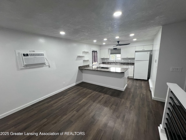 4733 S Pennsylvania Ave, Lansing, MI 48910 - kitchen with freestanding refrigerator, a peninsula, recessed lighting, a ceiling fan, and dark wood-type flooring