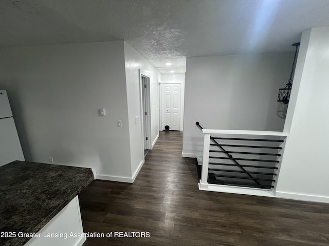 4733 S Pennsylvania Ave, Lansing, MI 48910 - corridor with an upstairs landing, dark wood finished floors, recessed lighting, and a textured ceiling