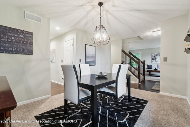 3901 W Howe Rd, Dewitt, MI 48820 - dining area with dark colored carpet, a chandelier, and stairway
