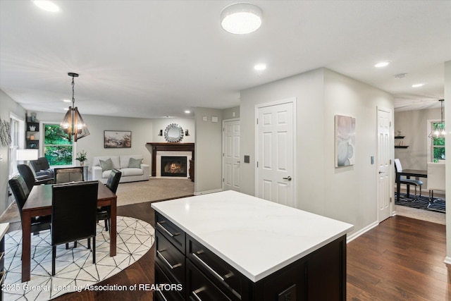 3901 W Howe Rd, Dewitt, MI 48820 - kitchen featuring a lit fireplace, dark cabinets, recessed lighting, light countertops, and dark wood-type flooring