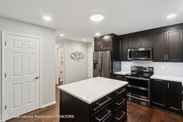3901 W Howe Rd, Dewitt, MI 48820 - kitchen with appliances with stainless steel finishes, light countertops, dark wood-style flooring, backsplash, and recessed lighting