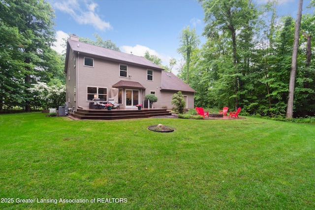 3901 W Howe Rd, Dewitt, MI 48820 - back of property with an outdoor fire pit, a chimney, a deck, and a lawn