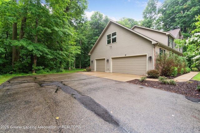 3901 W Howe Rd, Dewitt, MI 48820 - view of property exterior with asphalt driveway and a garage