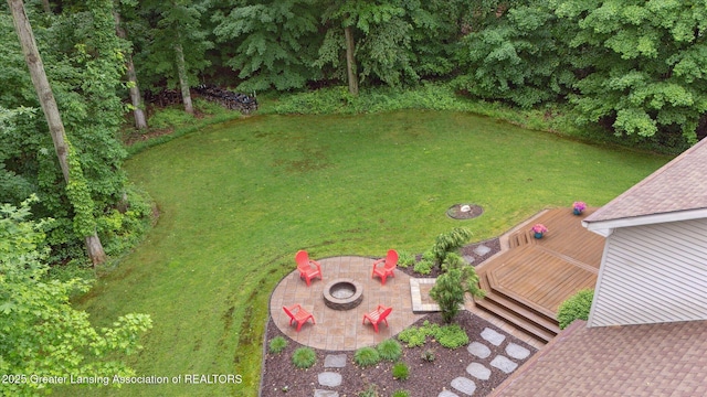 3901 W Howe Rd, Dewitt, MI 48820 - view of grassy yard featuring an outdoor fire pit, a wooden deck, and a patio area