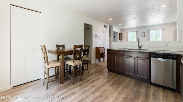 1118 River Oaks Dr, Dewitt, MI 48820 - kitchen with stainless steel dishwasher, light wood-style flooring, tasteful backsplash, dark brown cabinetry, and recessed lighting