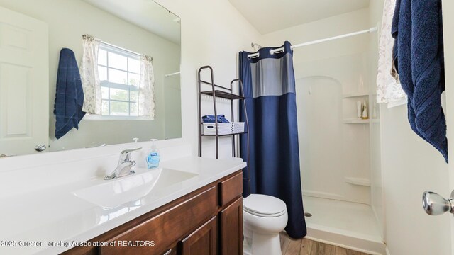 1118 River Oaks Dr, Dewitt, MI 48820 - bathroom featuring a stall shower, vanity, and wood finished floors