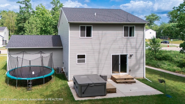 1118 River Oaks Dr, Dewitt, MI 48820 - back of house featuring a trampoline, a lawn, a patio area, and a shingled roof
