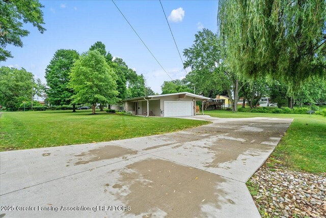 17 Charles E Pl, Battle Creek, MI 49015 - view of property exterior with an attached garage, a yard, and concrete driveway