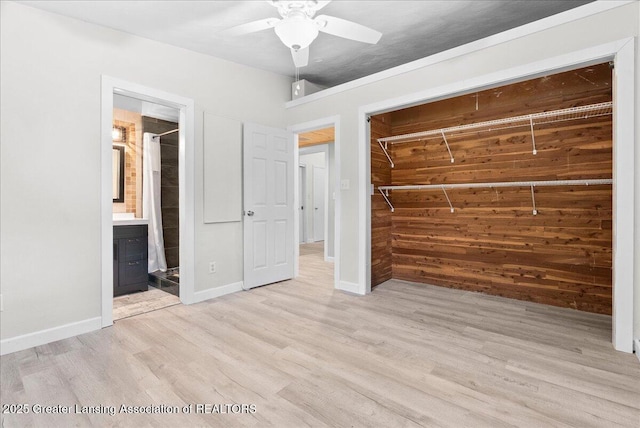 17 Charles E Pl, Battle Creek, MI 49015 - unfurnished bedroom with light wood-type flooring, a closet, a ceiling fan, connected bathroom, and wood walls
